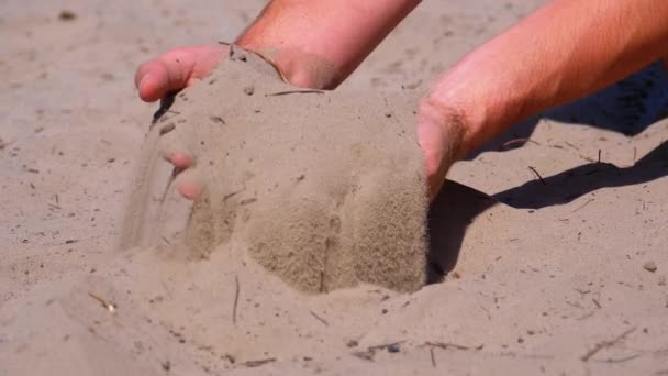 Mužské ruce padající písek na pláž v pomalém pohybu. Špinavý písek v rukou mužů — Stock video