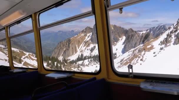 Okenní pohled na pohybující se horský vlak na zasněžené Švýcarské Alpy. Město Montreux. — Stock video