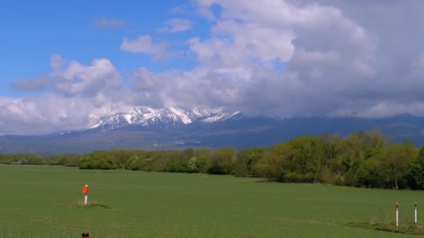 Панорамный вид на заснеженные Высокие Татры. Горные вершины в облаках — стоковое видео