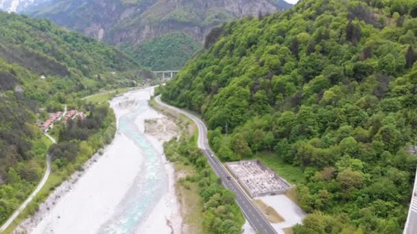 Flyga över en Bergs slingrande motorväg nära en fjällbäck — Stockvideo