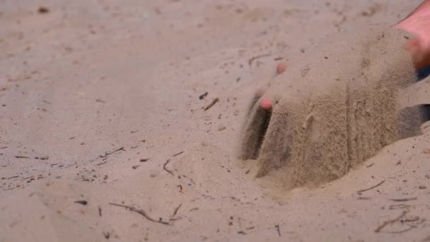 Sand Falls od człowieka s rękę na plaży w zwolnionym tempie. Brudny piasek w ręku mężczyzn — Wideo stockowe