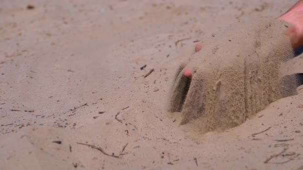 Areia cai de uma mão de homem na praia em câmera lenta. Areia suja na mão de homens — Vídeo de Stock