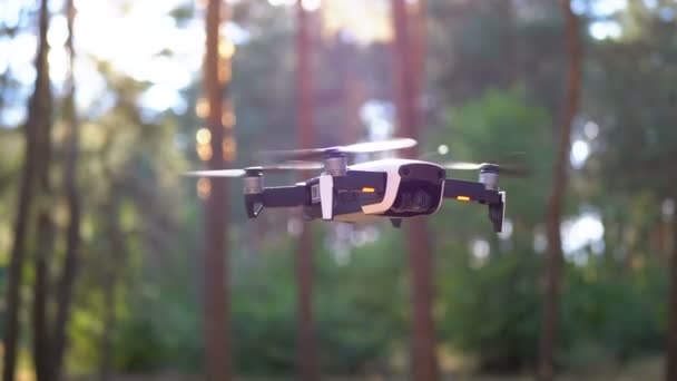 Um drone com uma câmara no ar. Voa acima do solo na floresta. Movimento lento — Vídeo de Stock