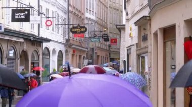 Şemsiyeli insanlar Yağmur Sırasında Eski Salzburg Sokaklarında Yürürler. Avusturya
