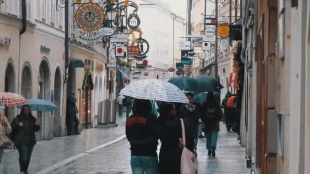 Ludzie z parasolami spacer na ulicach starego Salzburga podczas deszczu. Austria — Wideo stockowe