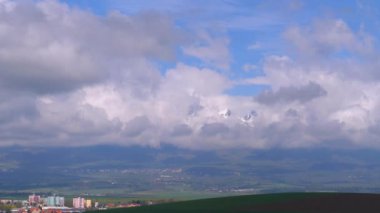 Karla kaplı Yüksek Tatras'ın panoramik manzarası. Bulutlarda dağ zirveleri