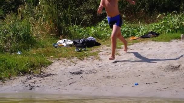 Boy Running into the Water on Shore of Beach and Creating Splashes in River. Mouvement lent — Video