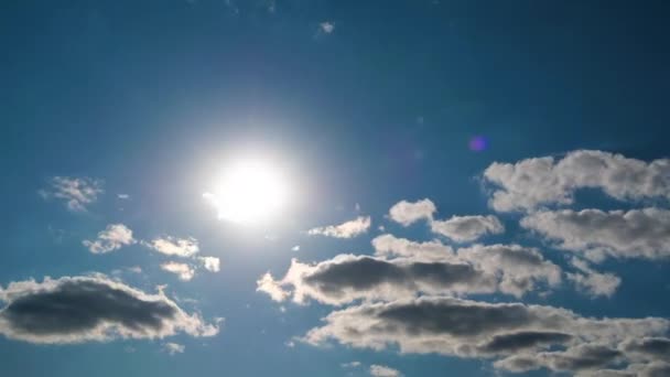 Las nubes se mueven suavemente en el cielo azul sobre el fondo del sol brillante. Cronograma — Vídeos de Stock