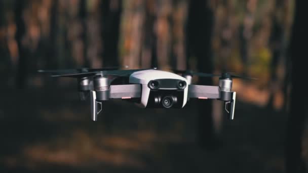 Drone with a Camera Hovers in the Air. Flies above the ground in the forest. Slow Motion — Stock Video