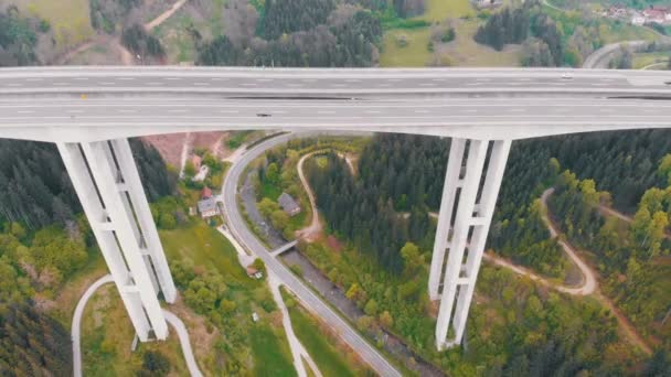 Vista aérea del viaducto de la autopista sobre pilares de hormigón con tráfico en las montañas — Vídeos de Stock