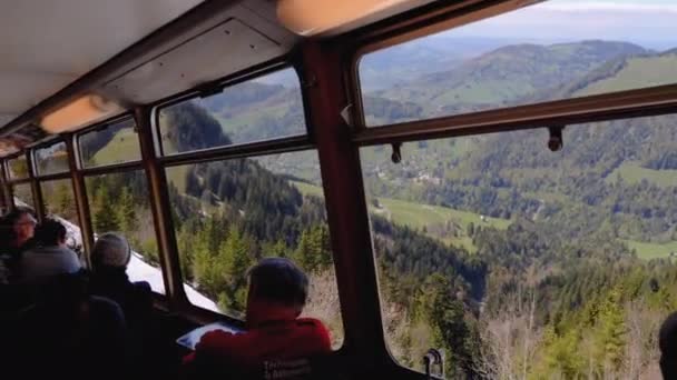 Blick aus der Kabine eines fahrenden Personenzuges mit Touristen an den Fenstern. Schweiz — Stockvideo