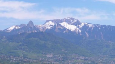 Karla kaplı İsviçre Alpleri'nin gökyüzüne karşı uzak manzarası. Bahar