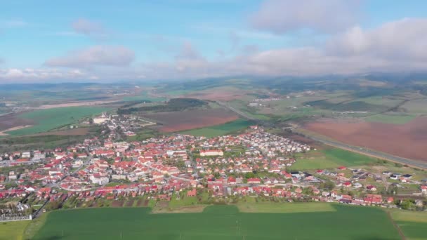 スピスキー城の近くの村や小さな町の空中ドローンビュー。スロバキア — ストック動画