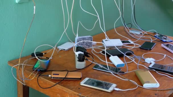 Muchos teléfonos inteligentes y teléfonos móviles de carga sobre la mesa — Vídeos de Stock