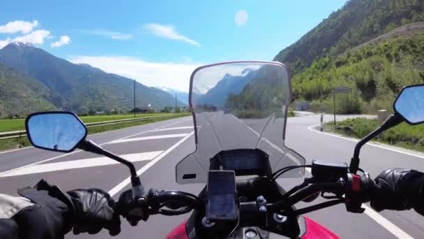 Motorradfahrer fährt auf wunderschöner Gebirgsstraße in der Nähe der verschneiten Schweizer Alpen — Stockvideo