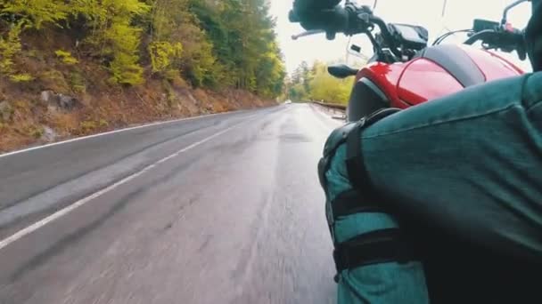 Motocyklista jezdí na malebných horských obloucích po silnici. Pohled ze strany. Pov. — Stock video
