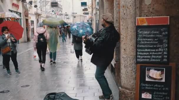 Musicien de rue jouant de la guitare sur Famous Street dans la vieille ville de Salzbourg sous la pluie. Autriche — Video