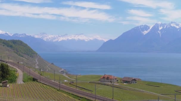 Paisaje vista del ferrocarril cerca del lago de Ginebra con viñedos y Alpes suizos. Suiza — Vídeos de Stock