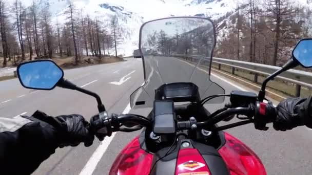 Motocyklista jedzie na pięknym krajobrazie Snowy Mountain Road w pobliżu Alp Szwajcarii — Wideo stockowe