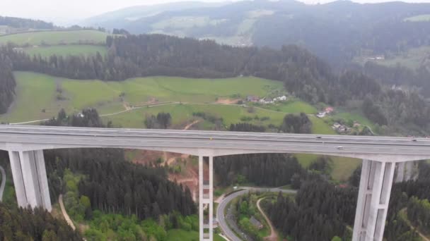 Luftaufnahme des Autobahnviadukts auf Betonpfeilern mit Verkehr in den Bergen — Stockvideo