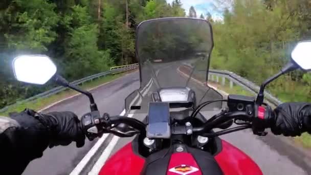 Motociclista Montar en el hermoso camino vacío cerca de árboles verdes y colinas — Vídeos de Stock