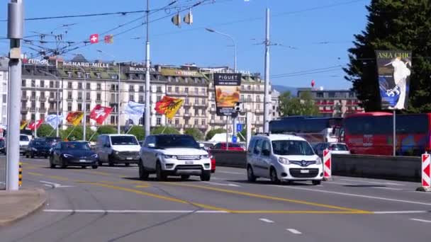 Mont-blanc-Brücke mit vorbeifahrenden Autos auf der Stadtstraße. Mittelbrücke mit Länderflaggen. Schweiz — Stockvideo