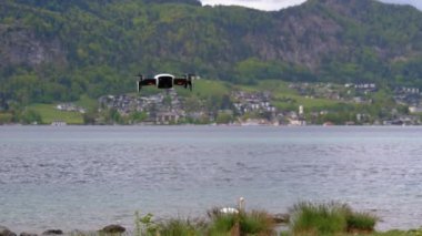 Göl ve Dağların Arkasında Havada Asılı Dönen Pervaneli Drone