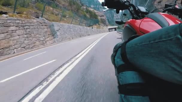 Motocyklista jezdí podél silnice na vyhlídkové horské zatáčce. Pohled ze strany. Pov. — Stock video