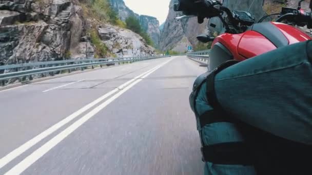 Motocyklista jezdí podél silnice na vyhlídkové horské zatáčce. Pohled ze strany. Pov. — Stock video