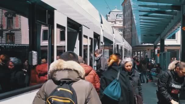 Folkmassan går in i en spårvagn vid en hållplats för kollektivtrafiken i Genève, Schweiz. — Stockvideo