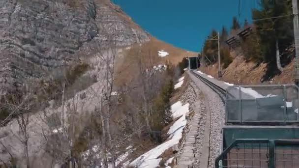 Przejazdy kolejowe w ośnieżonych górach na linii kolejowej. Szwajcaria, Alpy — Wideo stockowe