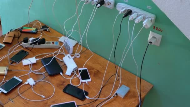Много смартфонов и мобильных телефонов зарядки на столе — стоковое видео