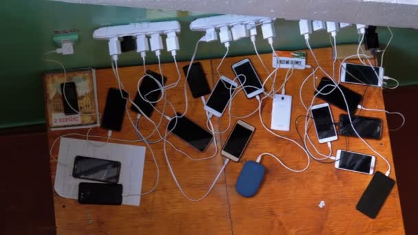 Veel smartphones en mobiele telefoons opladen op de tafel — Stockvideo