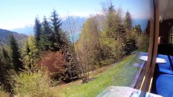 Vue fenêtre d'un train de montagne en mouvement sur les Alpes suisses enneigées. Montreux City . — Video