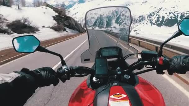 モーターサイクリストは、スイスアルプスの近くの美しい風景雪の山道に乗ります。スイス. — ストック動画