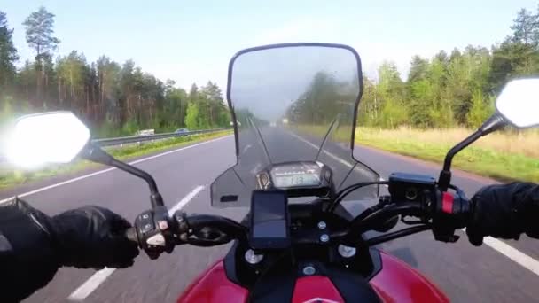 高速道路に乗ってモーターサイクリスト。オートバイの車輪の後ろから見る。Pov — ストック動画