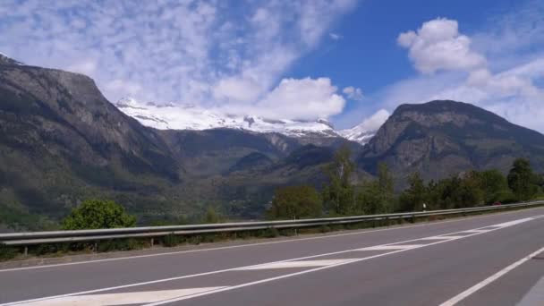 Панорамный вид на горные снежные вершины вблизи шоссе в швейцарских Альпах — стоковое видео