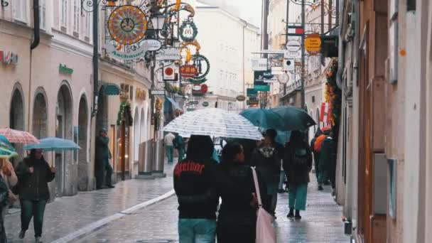 Люди с зонтиками ходят по улицам Старого Зальцбурга во время дождя. Австрия — стоковое видео