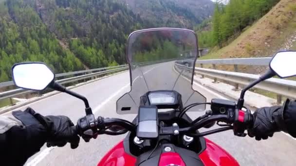 Motorradfahrer auf Motorrad unterwegs auf einer wunderschönen landschaftlichen Bergstrasse in der Nähe der Schweizer Alpen — Stockvideo