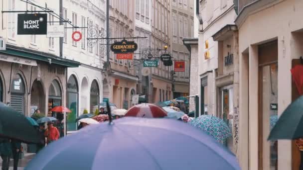 Personas con paraguas caminan por las calles de la antigua Salzburgo durante la lluvia. Austria — Vídeos de Stock