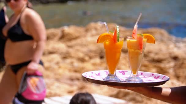 Serveur Servant des boissons sur la plage, Egypte. Serveur tenant un plateau avec des jus tropicaux — Video