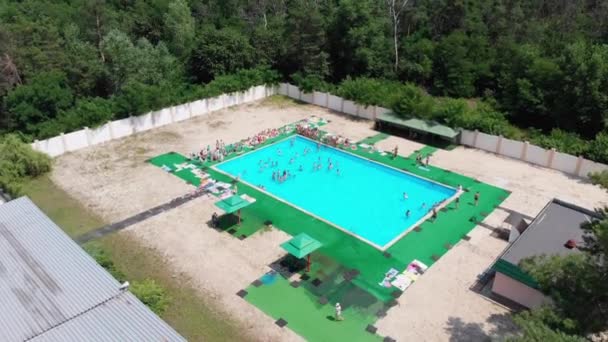 Volo sopra la piscina blu con persone in vacanza. Vista aerea sulla piscina pulita — Video Stock