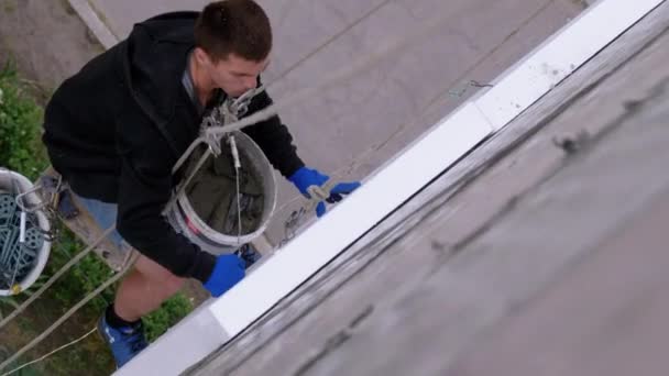 Industriell klättrare upphängd på rep isolat fasad med frigolit nära vägg — Stockvideo