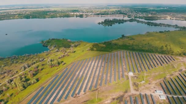 Güneşli günde, Nehir kenarındaki Yeşil Arazi 'deki Güneş Enerji İstasyonu' nda hava görüntüsü — Stok video