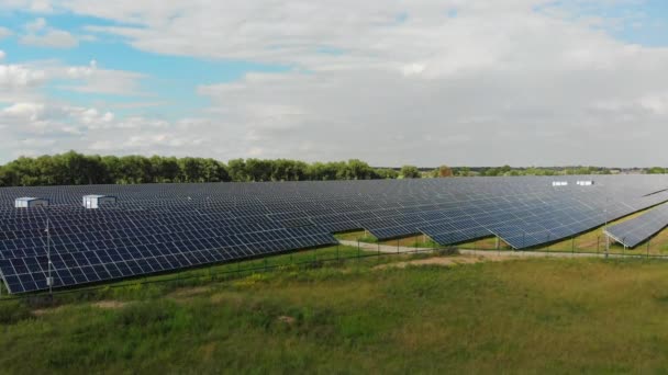 Widok z powietrza na elektrownię słoneczną. Panele stoją w rzędzie na Green Field. Lato — Wideo stockowe