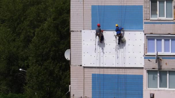 Due scalatore industriale, facciata di isolamento di grattacielo utilizzando polistirolo — Video Stock