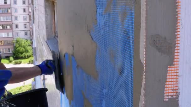 Industriekletterer verwendet Spachtelkitt auf Glasfasernetz, um Fassade zu isolieren — Stockvideo