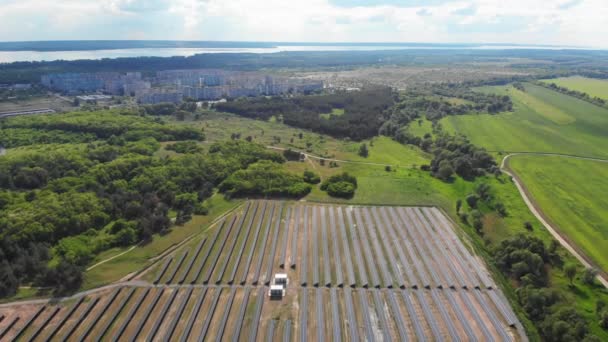 Letecký pohled na solární elektrárnu v Zeleném poli u malého města za slunečného dne — Stock video