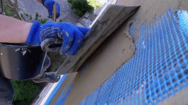 Endüstriyel dağcı, fiberglas örgü üzerinde Trowel macunu yapıştırıcısı kullanarak dış cepheyi izole ediyor. — Stok video