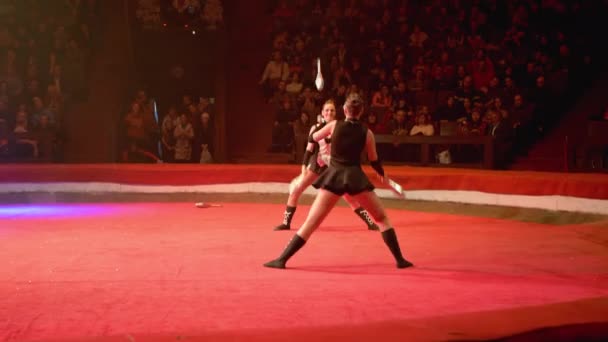 O Duo de meninas gêmeas malabarismo com clubes executa truques no palco do circo — Vídeo de Stock